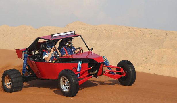 Dynamic Duo on Buggy Ride in Dubai Desert - Two passengers embarcing advnture, creating lasting memories on a exhilarating desert buggy experience.